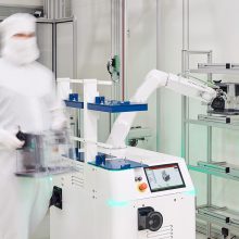 Automated Guided Vehicle (AGV) HERO FAB in the cleanroom handling and transporting wafers together with an operator