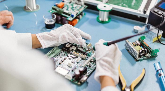 Person wearing gloves assembles and equips electronic assemblies or printed circuit board