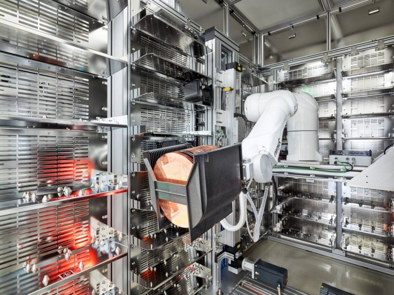 Interior view of the CubeStocker – a floor-based robot portal showing the 6-axis robot for handling wafers and the storage bays for wafer carriers.