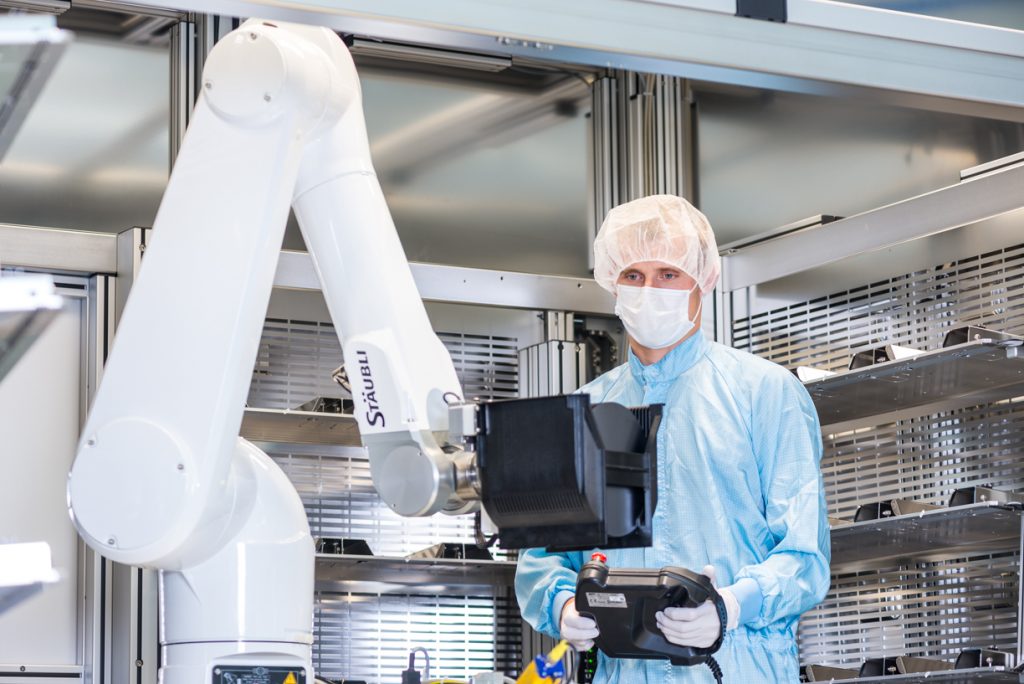Ein Ingenieur testet einen Roboter im Reinraum einer Halbleiterfabrik.